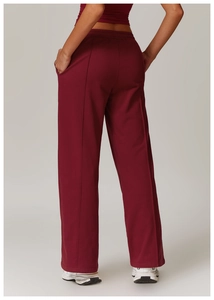Rear view of loose high-waist burgundy sports pants with elegant center pleats and soft fabric