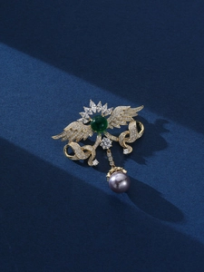 Detailansicht der goldener Engelsflügel Brosche mit Smaragd, Kristallen und Perle