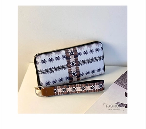 Macro detail of Bohemian geometric tribal pattern on long PU leather zipper wallet
