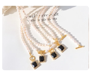 Macro detail of natural freshwater pearl necklaces with black zircon pendant and OT clasp