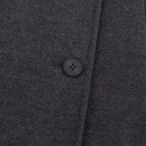 Detail of dark grey wool coat showing high-quality twill texture and black button