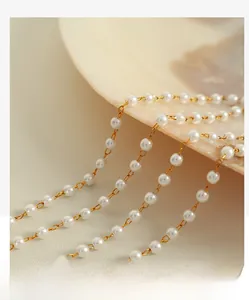 Dettaglio della collana di perle dorate su una conchiglia con maglie rifinite