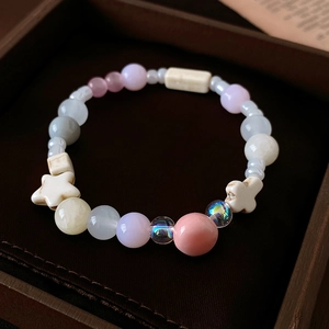 Makroaufnahme eines bunten Perlenarmbands mit Keramiksternen und Katzenaugensteinen