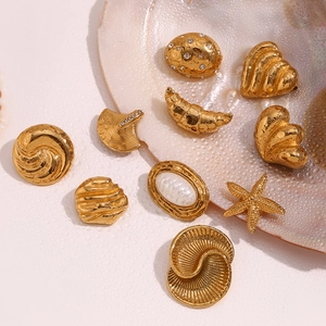 Macro detail of 18K gold plated earring set with starfish and shell designs on water drops