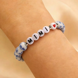 Dettaglio del bracciale in porcellana blu con perle di lettere MIMI e un cuore rosso