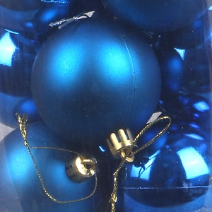 Boules de Noël bleues mates et brillantes avec cordons dorés dans leur boîte