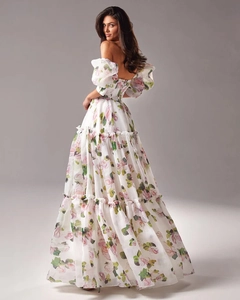 Détail de la robe longue en organza blanc avec imprimés floraux de roses et texture en maille