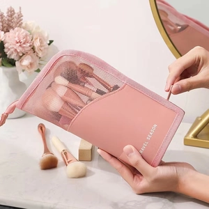 Pink mesh makeup brush travel organizer bag with zipper closure shown in a vanity setting