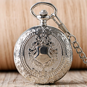 Makroaufnahme einer silbernen Vintage-Taschenuhr mit floralem Relief und Schildgravur