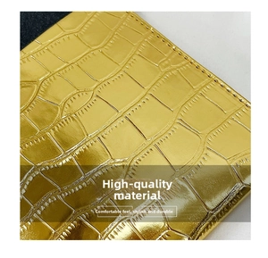 Close-up of golden stone-patterned leather with detailed stitching and metallic finish