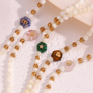 Close-up of beaded bracelets with white shell pearls and colored hexagonal stones