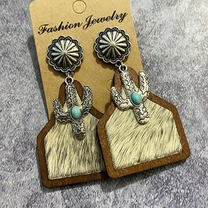 Detail of western earrings with cactus metal charm and faux cowhide fur texture