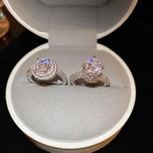 Luxury S925 silver rings with halo and six-prong crown settings in a white jewelry box