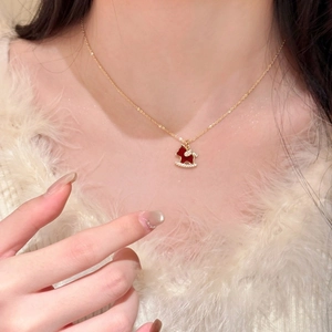 Close-up of 18K gold plated horse pendant necklace with red enamel and zircon accents