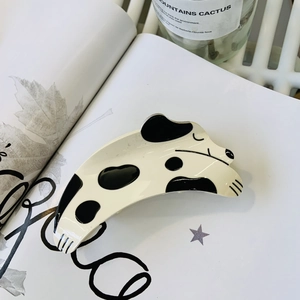 Pince à cheveux dalmatien chic en acrylique sur un fond de magazine moderne