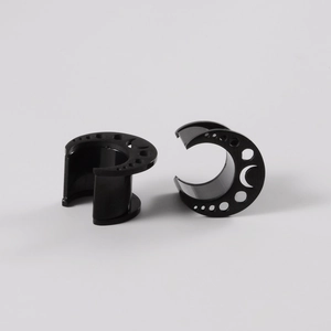 Macro detail of black saddle ear gauges with moon and star hollow-out patterns