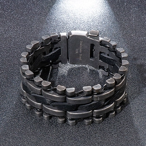 Close-up of 316L stainless steel clasp and black braided leather strap on a men's bracelet