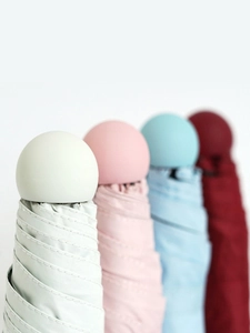 Detail of colorful capsule umbrellas with unique round handle tips and premium fabric