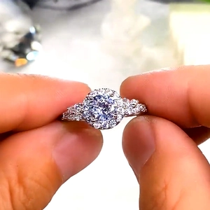 Sparkling silver round cluster engagement ring with pavé stones and halo setting design