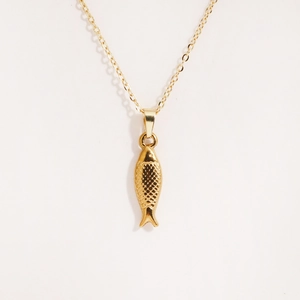 Detailed macro view of tropical fish pendant with scale texture on golden O-chain necklace