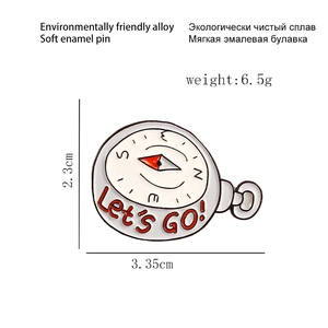 Detailed compass soft enamel brooch with red pointer and Let's GO text on white background