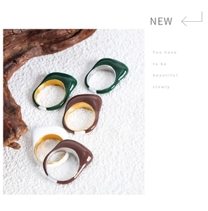 Detail of colorful enamel stackable rings in green and brown on a rustic wood stand
