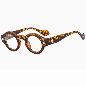 Detail of round tortoiseshell sunglasses with silver metal rivets on a white background