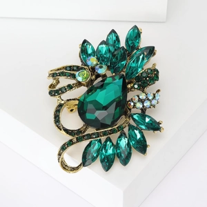 Vintage emerald crystal brooch with pear-shaped green stone in an antique gold base