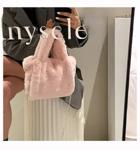 Sac à main rose en peluche avec chaîne dorée présenté dans un selfie devant un miroir