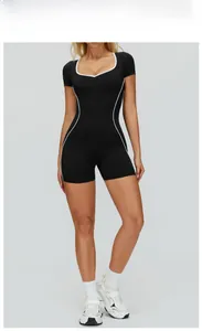 Front view of black slim-fit bodysuit with white contrast piping for yoga and fitness
