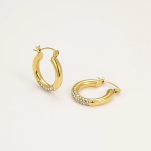 Close-up of gold hoop earrings featuring clear pavé set crystals and polished finish