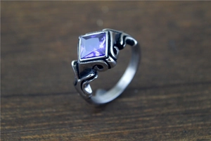 Macro shot of purple square cut gemstone ring with vintage silver gothic engravings