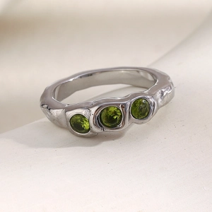 Close-up of silver steel ring with three green stones and lava texture design