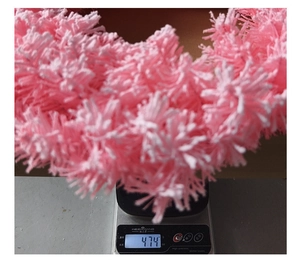 Detailed view of a soft pink fluffy Christmas wreath weighing 474g on a silver digital scale