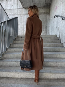 Detail of a brown wool coat featuring a stylish side slit and matching waist belt ties
