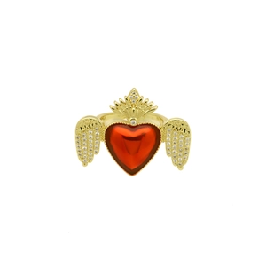 Detail shot of a gold heart ring with red stone and zircon wings on white background