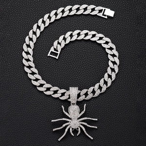 Macro shot of silver gothic spider pendant with crystals on sparkling cuban link chain