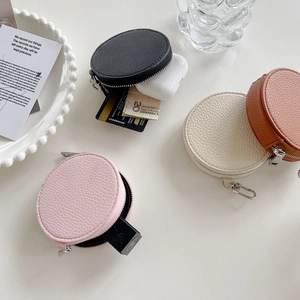 Close-up of circular leather coin purses showing storage of earphones and cards