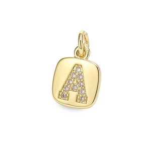 Macro detail of gold square alphabet A pendant with sparkling zircon inlays