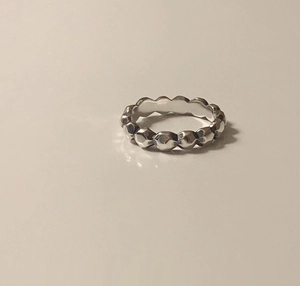 Macro shot of silver minimalist ring featuring a geometric multifaceted surface design