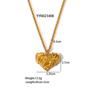 Detail of golden heart pendant with irregular rippled texture and link chain