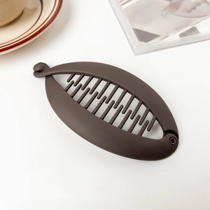 Close-up of dark brown matte banana hair clip showing anti-slip inner teeth and design