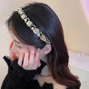 Elegant headband with champagne crystals and white pearls worn by a female model