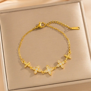 Bracelet trèfle doré élégant avec pierres en zircone cubique sur un écrin de bijoux de luxe