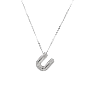 Macro detail of silver U letter pendant with sparkling zircon paving on micro chain