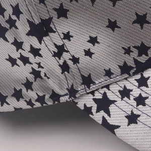 Gros plan du tissu gris argenté avec motif d'étoiles bleues et double couture sur la casquette