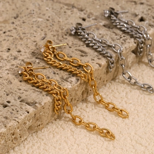 Detailed macro view of gold and silver chain tassel earrings with sparkling cubic zirconia