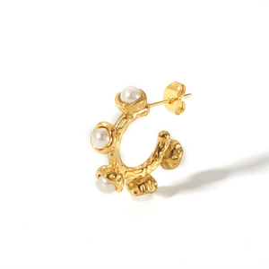 Detail of 18K gold plated C-shaped earring featuring irregular texture and inlaid pearls