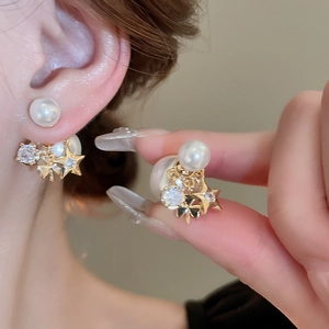 Star flower faux pearl earrings with gold plating and rhinestones on ears