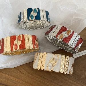 Detail view of retro elastic bracelets with wave pattern metal and colorful enamel finish
